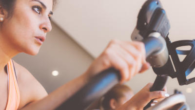 A woman with a determined look excercising at a gym.